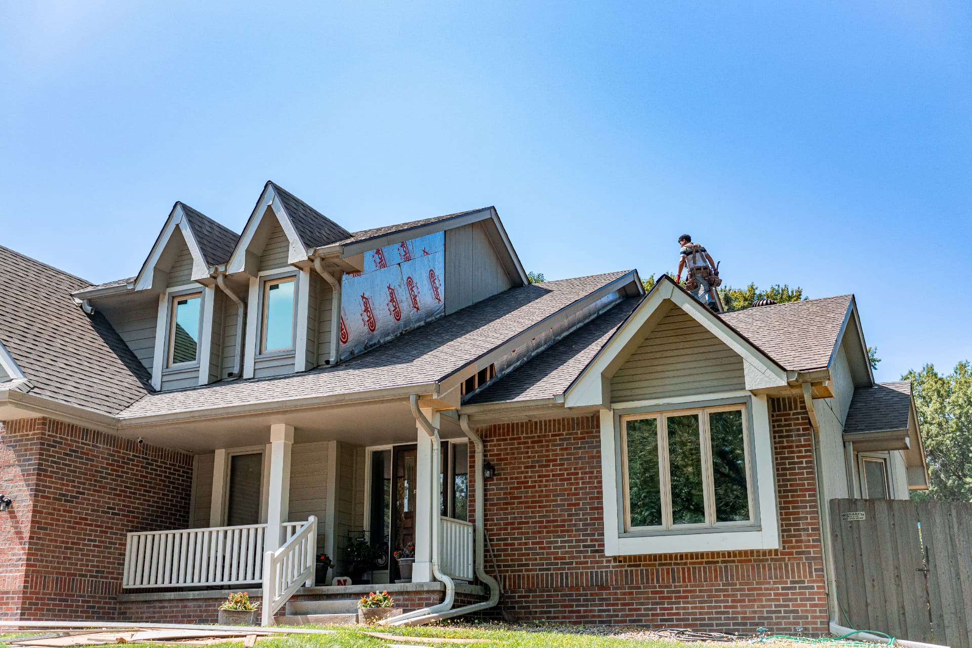 Alfa Y Omega crew member on the roof of an Omaha home during a siding and roofing project